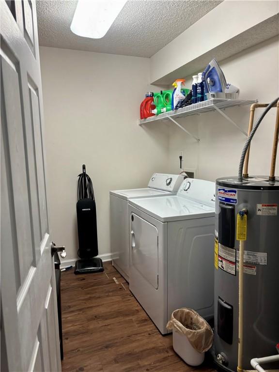 clothes washing area featuring washer and dryer, dark wood-style flooring, laundry area, a textured ceiling, and electric water heater
