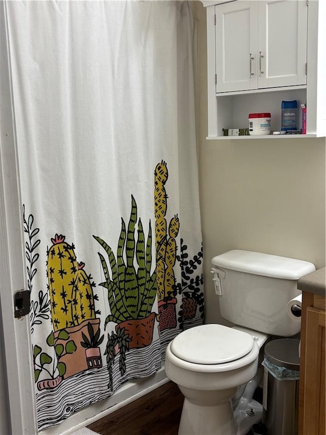 bathroom featuring wood finished floors and toilet