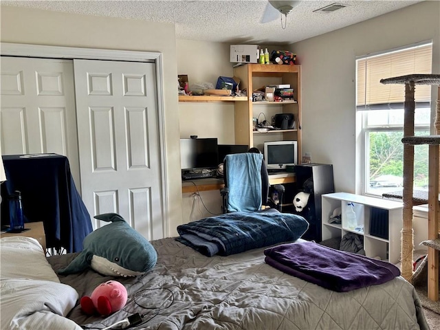 bedroom with carpet floors, a closet, a textured ceiling, and visible vents