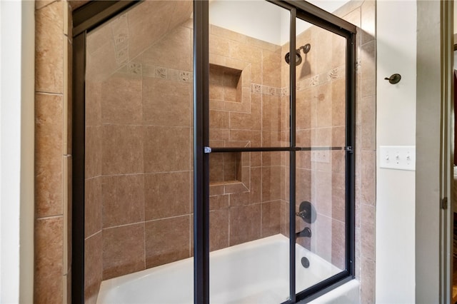 bathroom with bath / shower combo with glass door