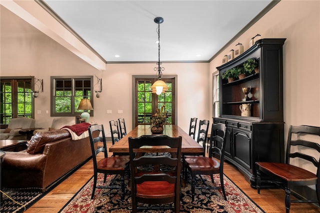 dining area featuring ornamental molding and light wood finished floors