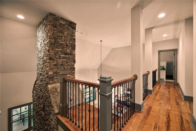 hall featuring visible vents, wood finished floors, baseboards, an upstairs landing, and recessed lighting