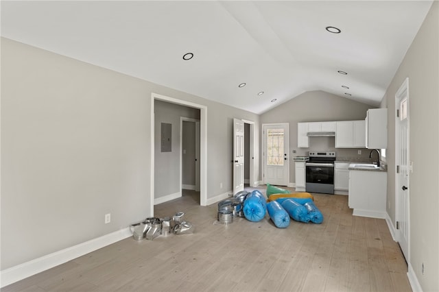 kitchen with white cabinets, electric range, a sink, light wood finished floors, and vaulted ceiling