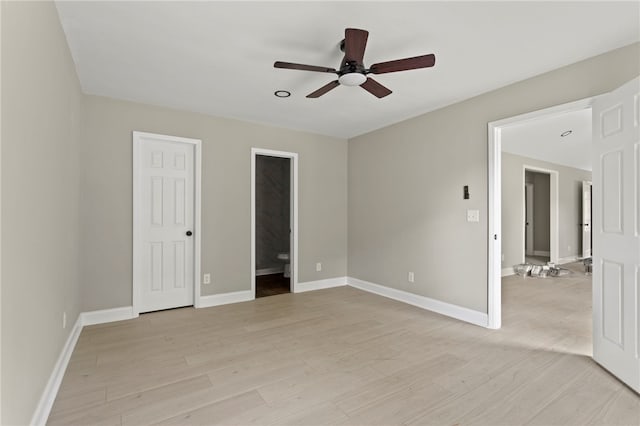 unfurnished bedroom featuring baseboards, light wood-style flooring, and ensuite bathroom