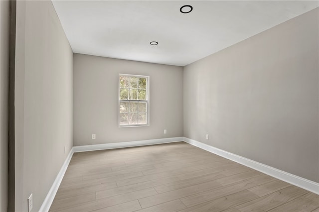 unfurnished room with baseboards and light wood finished floors