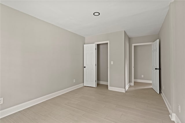 unfurnished bedroom with baseboards and light wood-style floors