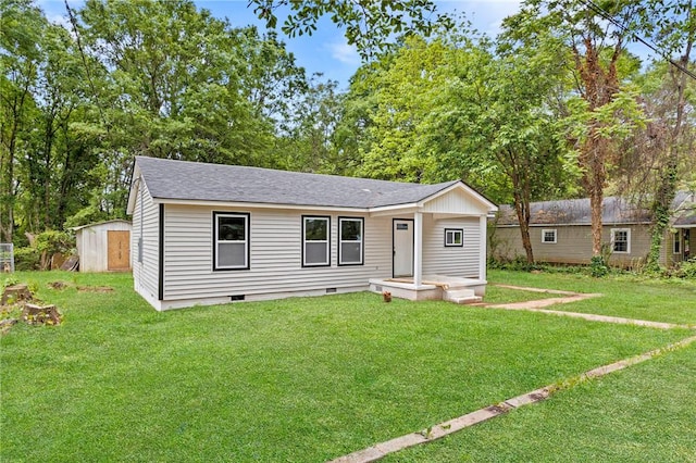 ranch-style house with an outdoor structure, a shingled roof, a front lawn, and crawl space