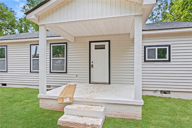 entrance to property featuring a yard, crawl space, and a shingled roof