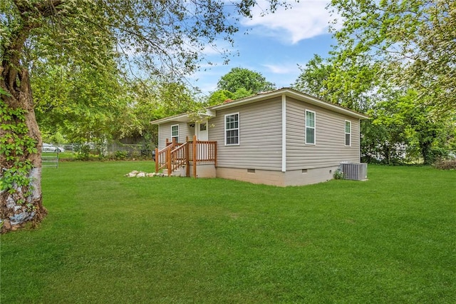 rear view of house featuring a yard, central AC, and crawl space