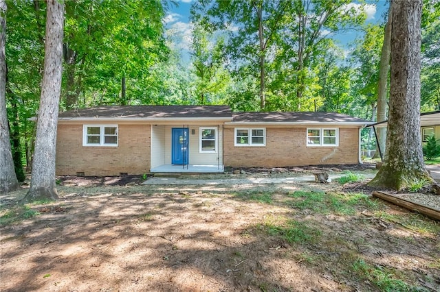 back of house with crawl space and brick siding
