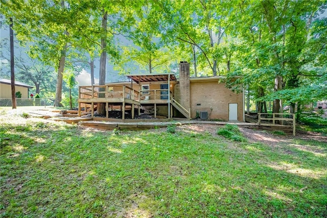 back of house with fence, stairs, a wooden deck, a chimney, and a yard