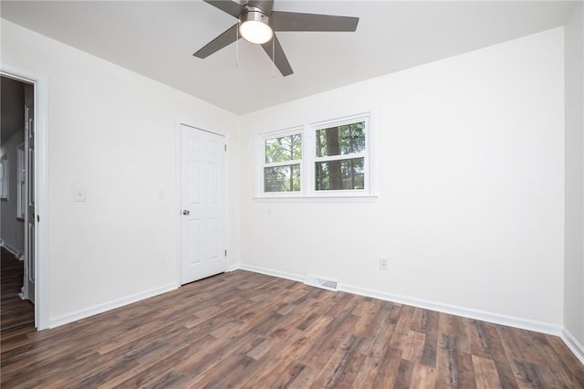 unfurnished bedroom featuring dark wood-style flooring, baseboards, visible vents, and a ceiling fan