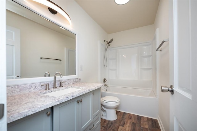 bathroom with toilet, washtub / shower combination, wood finished floors, and vanity