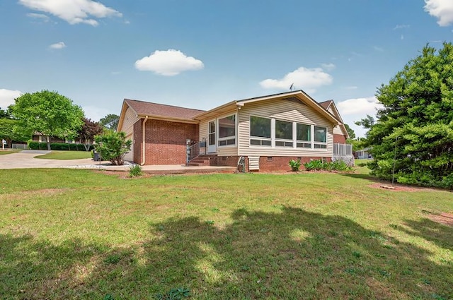 exterior space featuring brick siding, driveway, crawl space, and a front yard