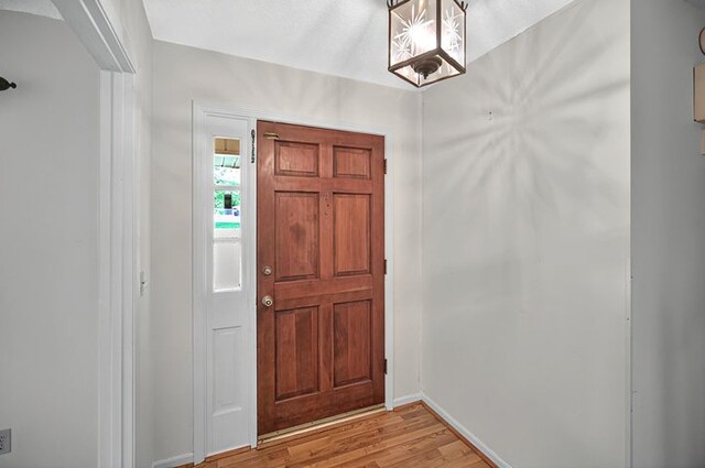 foyer entrance with baseboards and light wood-type flooring