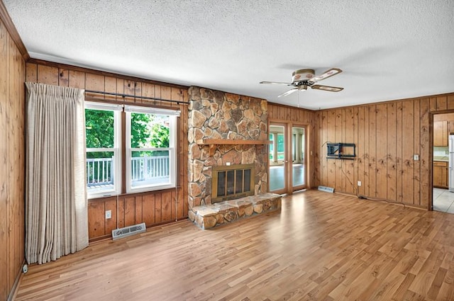 unfurnished living room featuring visible vents, wood finished floors, and a wealth of natural light