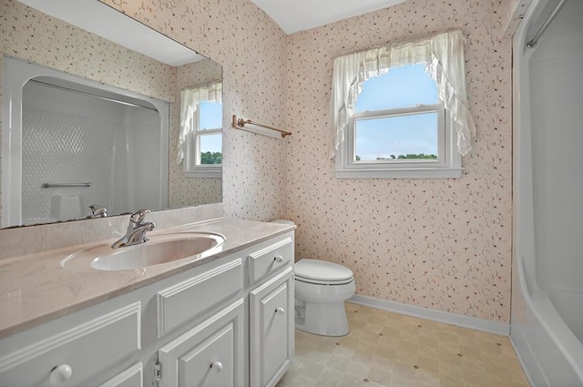 bathroom with vanity, walk in shower, toilet, and wallpapered walls