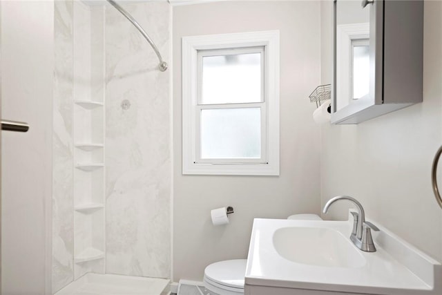 bathroom featuring vanity, toilet, and a shower