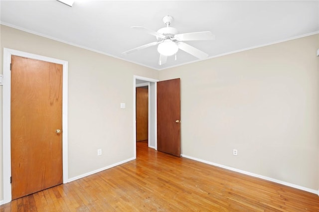 unfurnished bedroom with baseboards, light wood-style flooring, and crown molding