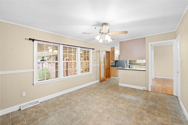 unfurnished living room featuring crown molding, ceiling fan, visible vents, and baseboards