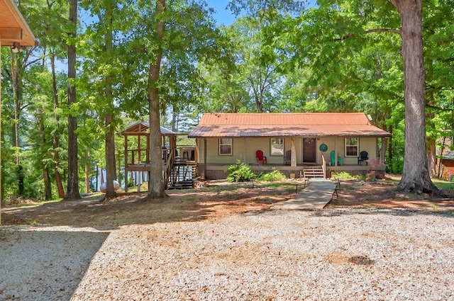 ranch-style home with a porch and metal roof