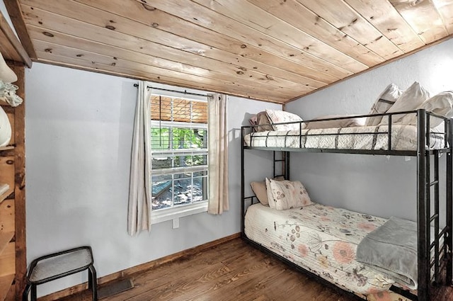 bedroom featuring baseboards, wood ceiling, and wood finished floors