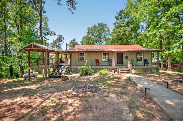 ranch-style home with a porch and metal roof