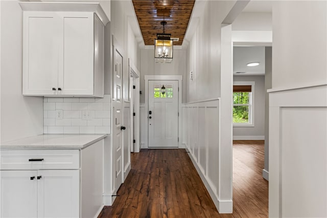 604 Robin Hood Ln, Anderson, SC 29621 - hall featuring baseboards, an inviting chandelier, and dark wood-type flooring