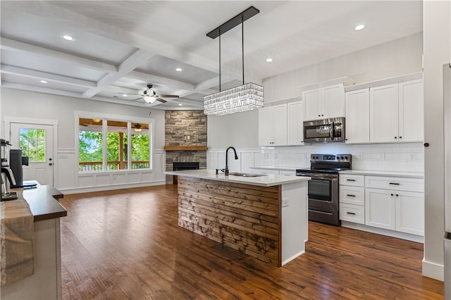604 Robin Hood Ln, Anderson, SC 29621 - kitchen featuring appliances with stainless steel finishes, a sink, a stone fireplace, a ceiling fan, and dark wood-style floors