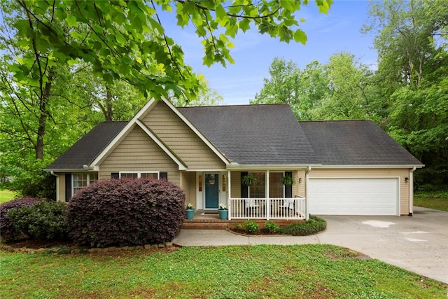 view of front of property featuring a shingled roof, a front lawn, a garage, a porch, and driveway