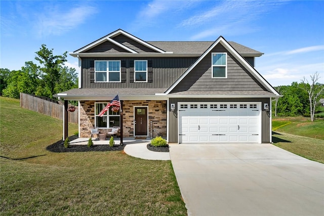 craftsman-style house featuring a porch, a front yard, fence, concrete driveway, and stone siding