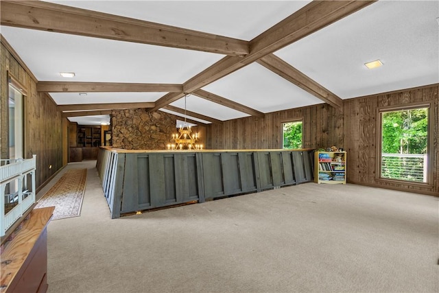 spare room featuring wooden walls, a chandelier, lofted ceiling with beams, and carpet floors