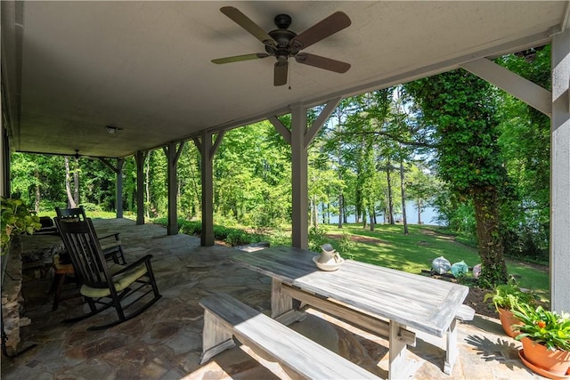 view of patio / terrace featuring a water view, outdoor dining space, and ceiling fan