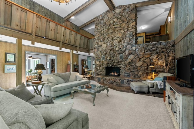carpeted living area featuring high vaulted ceiling, ceiling fan, beam ceiling, and a stone fireplace