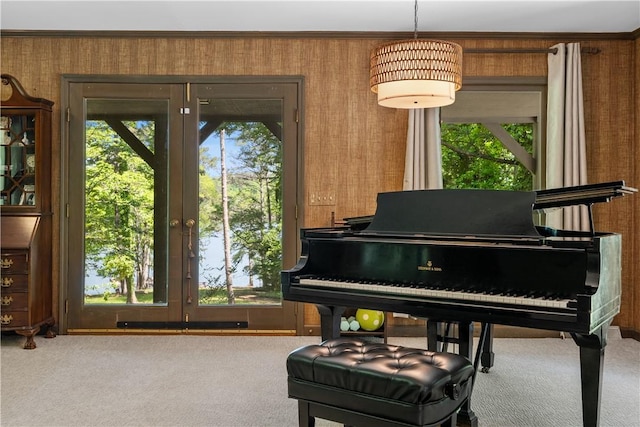 sitting room with carpet floors, wallpapered walls, crown molding, and french doors