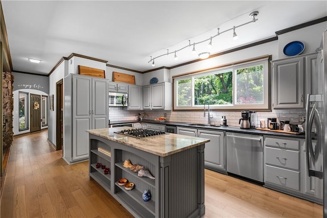 kitchen featuring a sink, a center island, stainless steel appliances, gray cabinetry, and ornamental molding