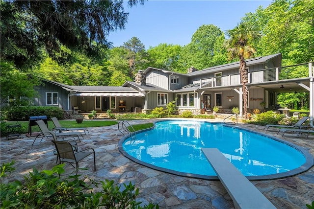 pool featuring a patio and a diving board