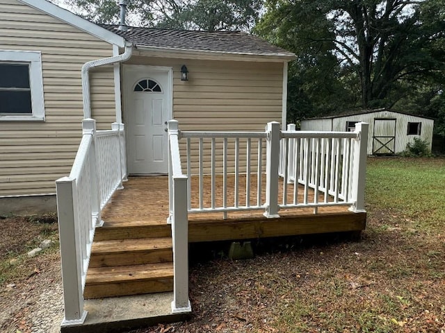 entrance to property featuring a shingled roof and a deck