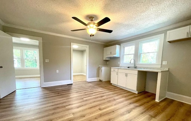 kitchen featuring white cabinetry, a textured ceiling, and light wood-style flooring