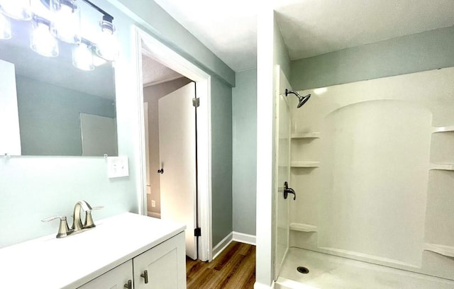 full bath with vanity, wood finished floors, and a shower stall