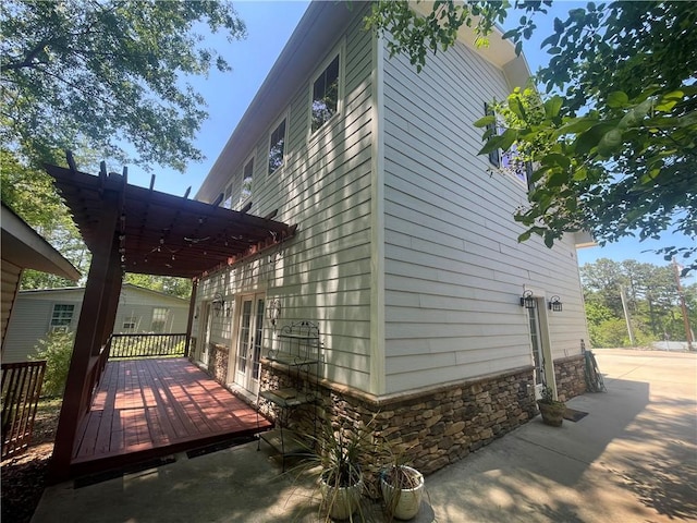 view of home's exterior with a wooden deck and stone siding