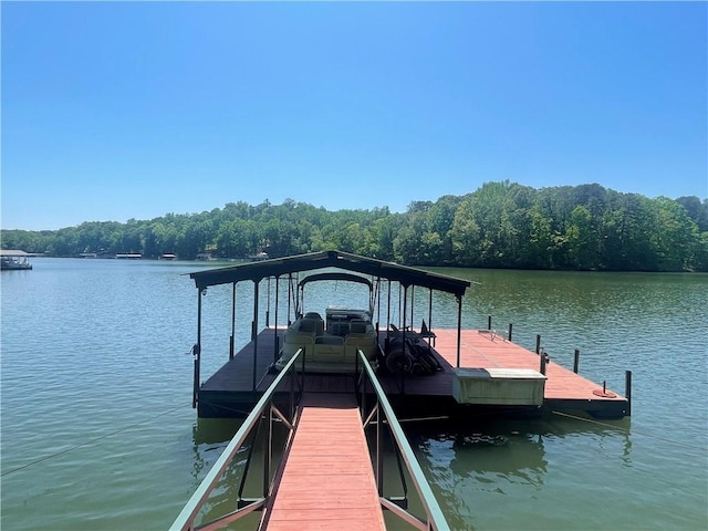 dock area featuring a water view and a wooded view