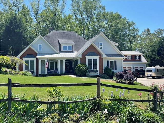 craftsman inspired home with covered porch, a standing seam roof, metal roof, a front yard, and fence