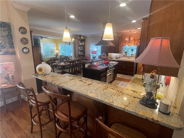 kitchen featuring island exhaust hood, ornamental molding, light wood finished floors, and light stone countertops