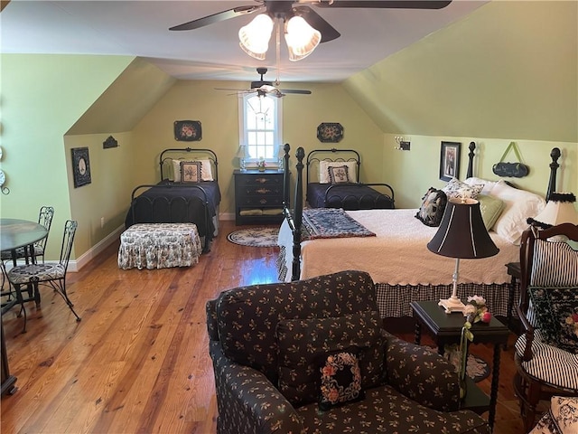 bedroom featuring baseboards, ceiling fan, vaulted ceiling, and wood finished floors