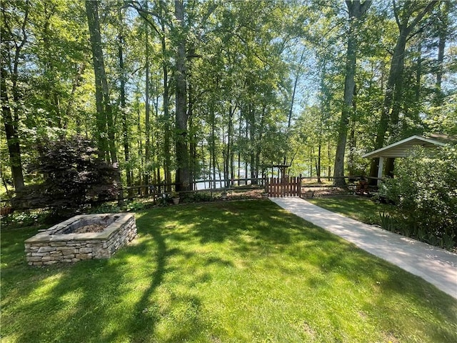 view of yard featuring a gate, fence private yard, and an outdoor fire pit