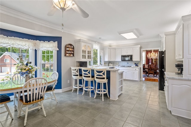 kitchen featuring light countertops, a peninsula, a breakfast bar, and a wealth of natural light