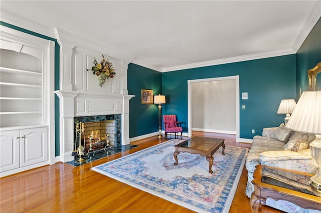 living room with a premium fireplace, baseboards, ornamental molding, and wood finished floors