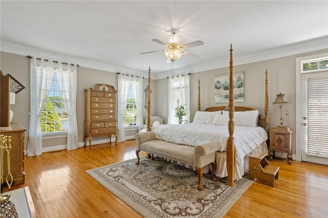 bedroom featuring multiple windows, ornamental molding, and light wood-type flooring