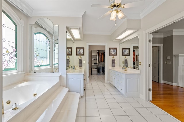 bathroom with crown molding, tile patterned flooring, vanity, a ceiling fan, and a tub with jets